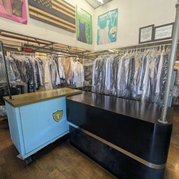 Inside Mr Best One Hour Cleaners — the front counter and racks of cleaned, pressed garments